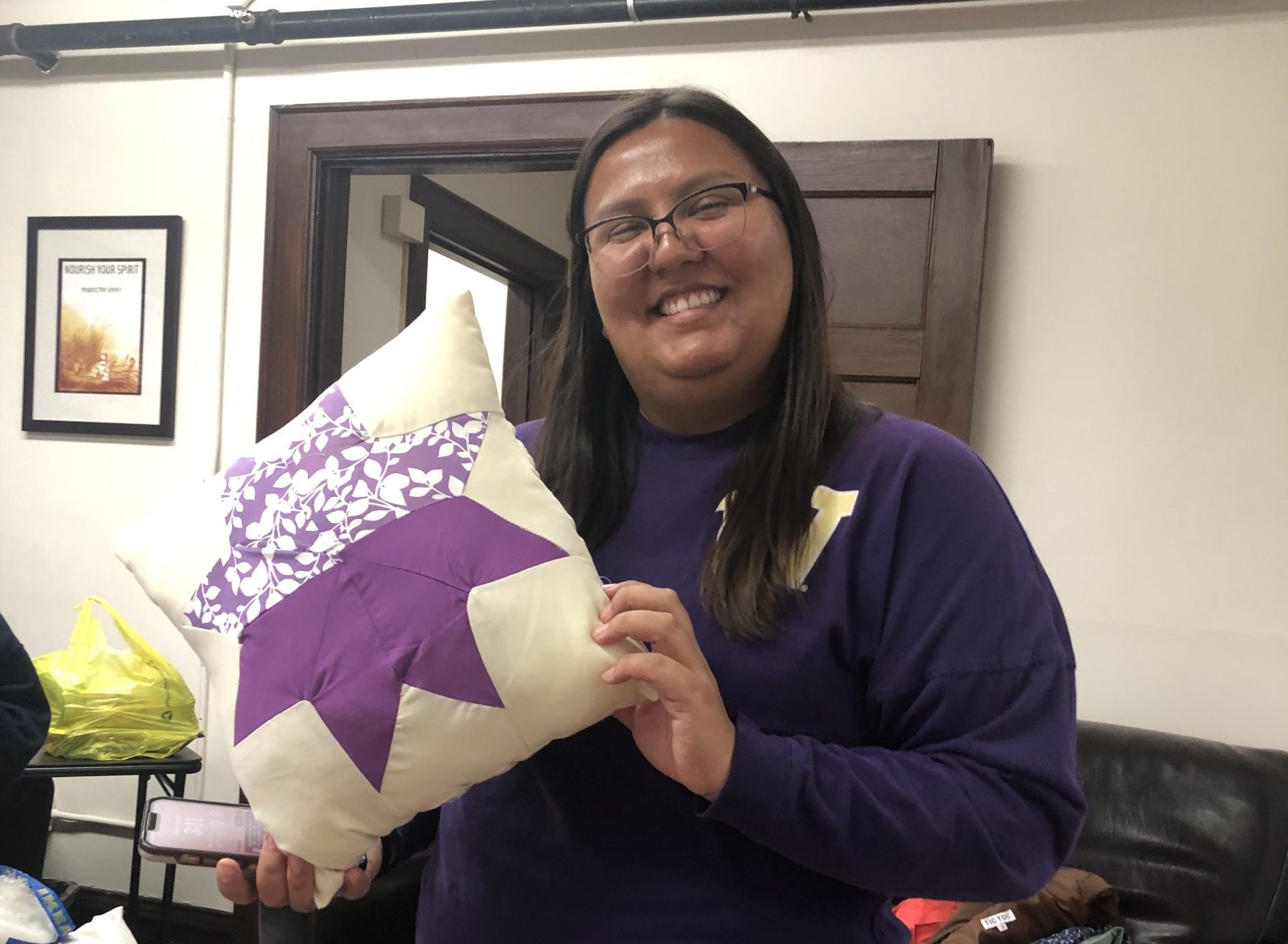 Smiling woman holding a quilt pillow