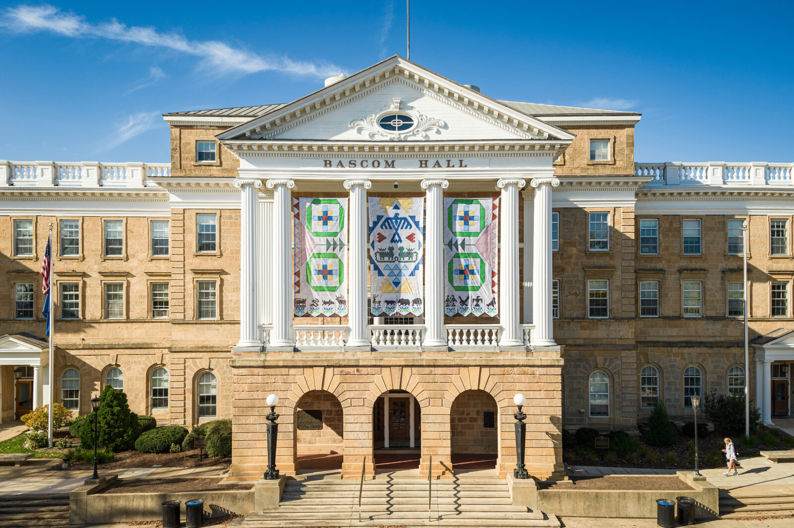 Ho-Chunk banners are pictured hanging between the building columns of Bascom Hall 